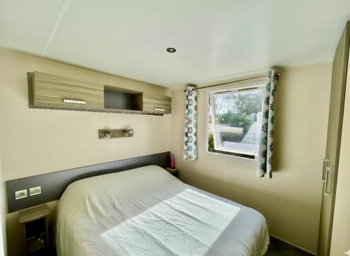 a small bedroom with a bed and a window at Bungalow au pied des gorges de Baudinard à Montagnac-Montpezat in Saint-Laurent-du-Verdon