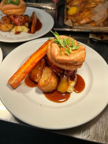 a plate of food with a carrot on a table at Jug and glass in Highpeak Junction