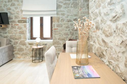 a dining room table with a vase of flowers on it at MONOPATI HOUSE in Mouzákion