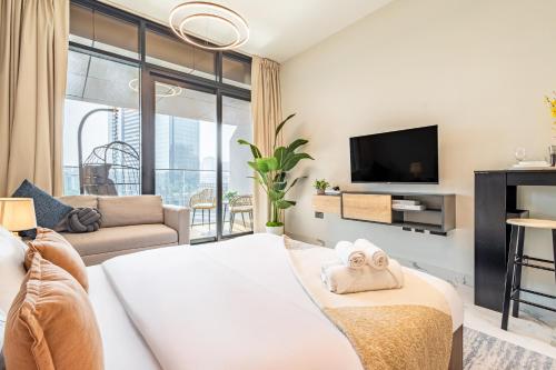 a living room with a couch and a tv at Charming Studio - Full Canal Views - 5 min walk from ADGM, Cleveland and Galleria - Perfect for Corporate Travelers - Big Balcony - Heart of Maryah Island in Abu Dhabi