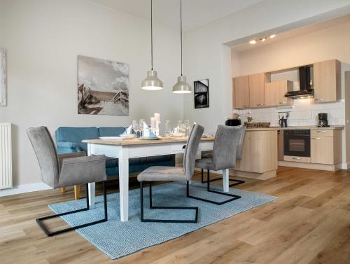 a kitchen and dining room with a white table and chairs at Ostsee Residenz Meeresblick Dünenblick in Insel Poel