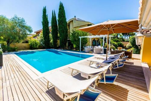 a swimming pool with lounge chairs and an umbrella at B&B Le Lanterne in Casal Palocco