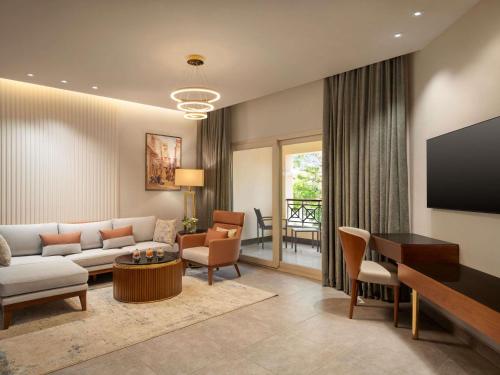 a living room with a couch and a table at Mövenpick Hotel Cairo - Media City in 6th Of October