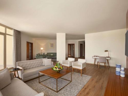 a living room with a couch and a table at Mövenpick Hotel Cairo - Media City in 6th Of October