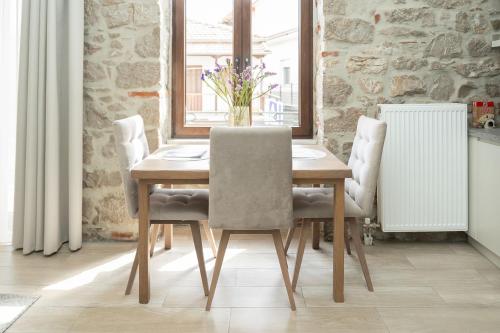 a wooden table with chairs and a vase of flowers at MONOPATI HOUSE in Mouzákion