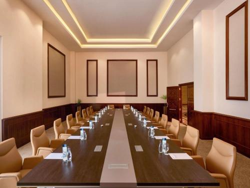 a large conference room with a long table and chairs at Mövenpick Hotel Cairo - Media City in 6th Of October