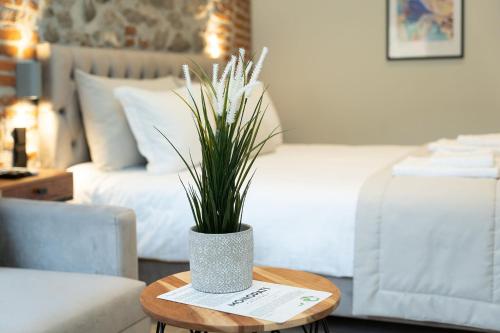 a vase with a plant on a table in a bedroom at MONOPATI HOUSE in Mouzákion