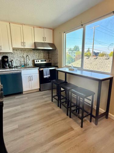 a kitchen with a counter with stools and a large window at Private Room by UW in Seattle