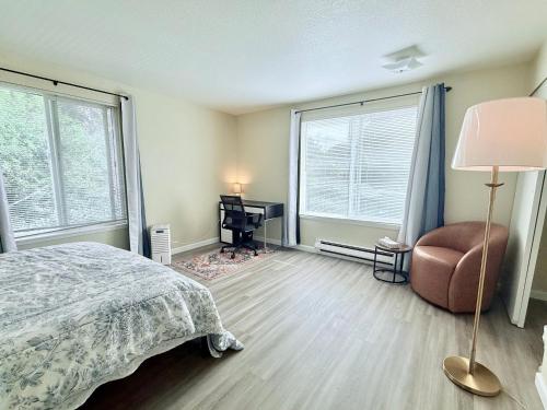 a bedroom with a bed and a chair and windows at Private Room by UW in Seattle