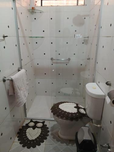 a white bathroom with a toilet and a shower at Quarto suite master para 3 pessoas in Belém