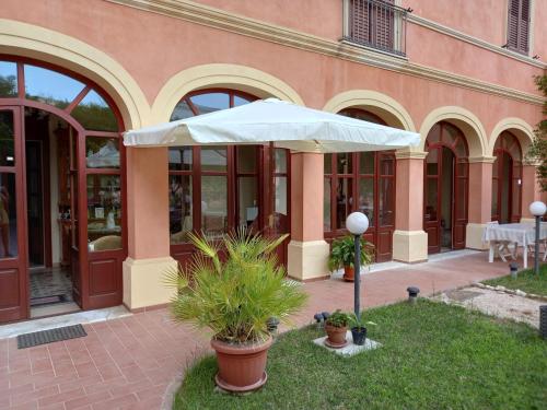 a white umbrella in front of a building at Oasi Ottocento in Quartu SantʼElena