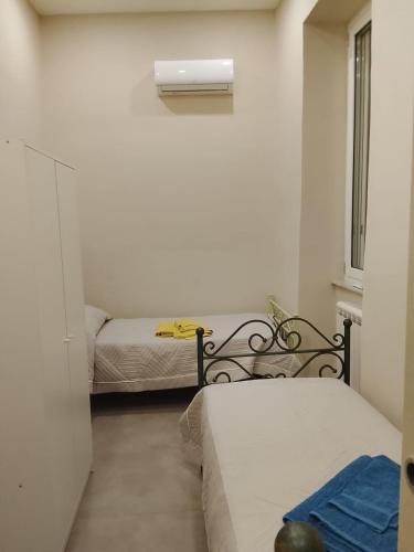 a bedroom with two beds and a window at GIOIA Holiday Home in Torre del Greco