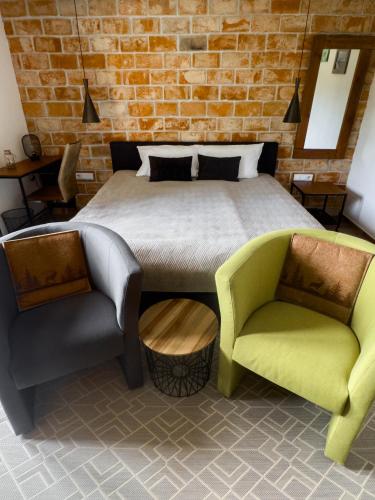 a bedroom with a bed and two chairs at O'Toole's, Plitvice in Korenica
