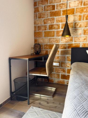 a desk with a chair next to a brick wall at O'Toole's, Plitvice in Korenica