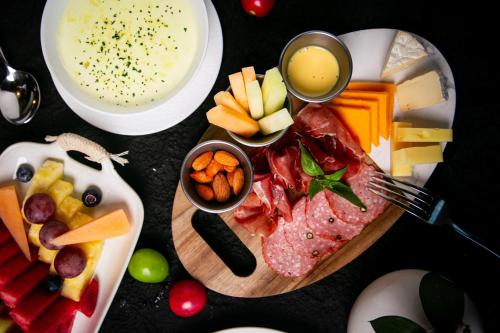 a table topped with a plate of food with cheese and fruit at Regent Chongqing - Complimentary 1st round mini bar daily in Chongqing