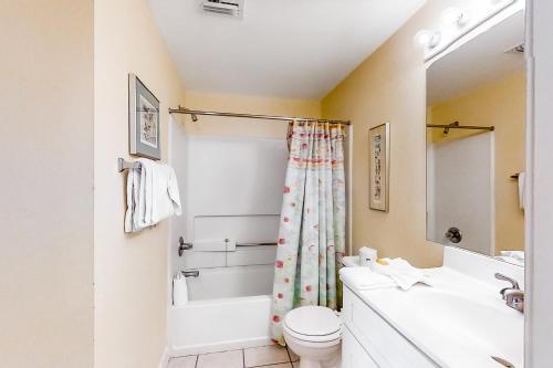 a bathroom with a sink and a toilet and a tub at Emerald Towers West 5007 in Fort Walton Beach
