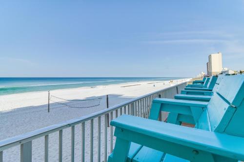 a blue bench sitting on a boardwalk next to the beach at Fontainebleau 305 in Panama City Beach