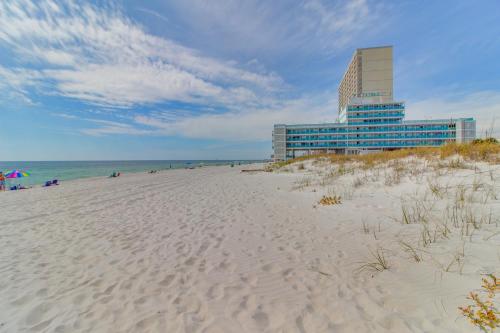 a beach with a building in the background and a building at Fontainebleau 305 in Panama City Beach