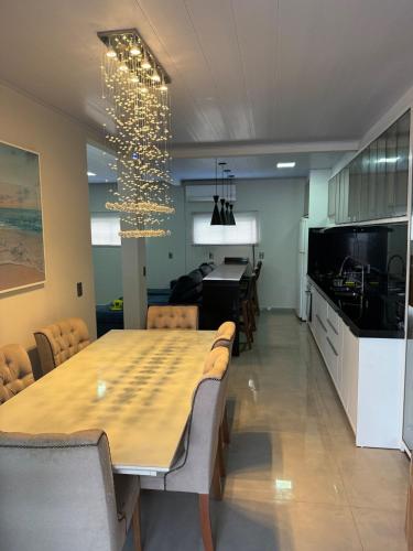 a dining room and kitchen with a table and chairs at House in the center of Bauneario Picarras in Piçarras