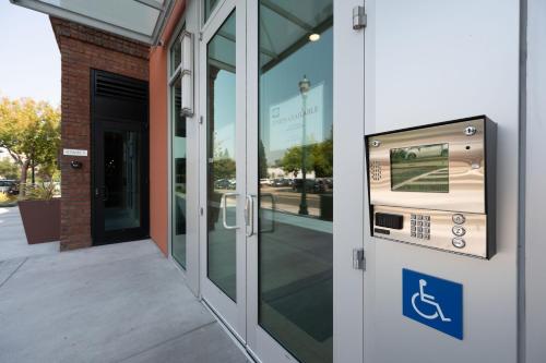 a door to a building with a handicap sign on it at Elevator-Downtown View-Garage-King Bed-Laundry in Walnut Creek