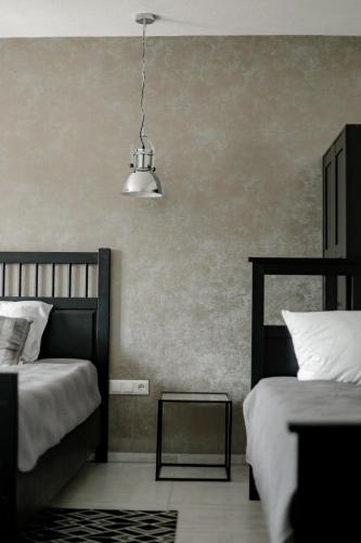 a bedroom with two beds and a hanging light at O'Toole's, Plitvice in Korenica