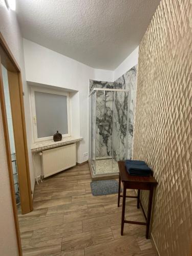 ein Flur mit einem Tisch und einer Dusche in einem Zimmer in der Unterkunft Ferienwohnung-Oberstein im Zentrum in Idar-Oberstein