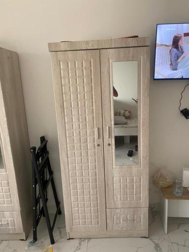 a wooden door with a mirror in a room at عجمان هايتس in Ajman 