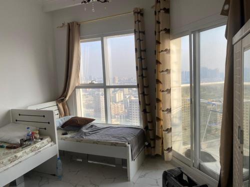 una piccola camera da letto con un letto e una finestra di عجمان هايتس ad Ajman