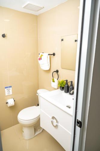 a bathroom with a toilet and a sink at Casa Toñita in Levittown