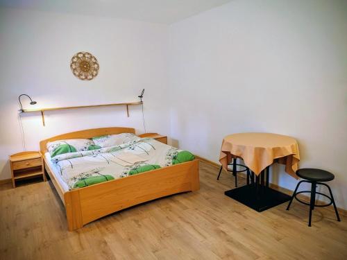 a bedroom with a bed and a small table at Penzion Betlém in Janske Lazne