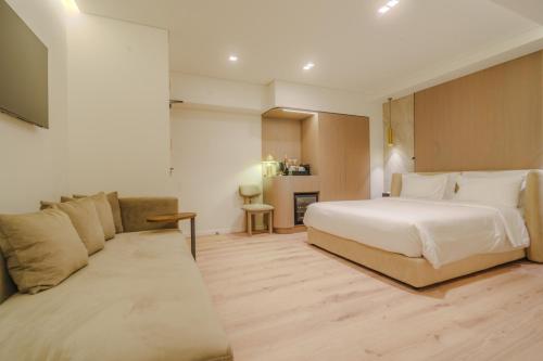 a hotel room with a bed and a couch at Eternity Athens -Opening 2025- in Athens