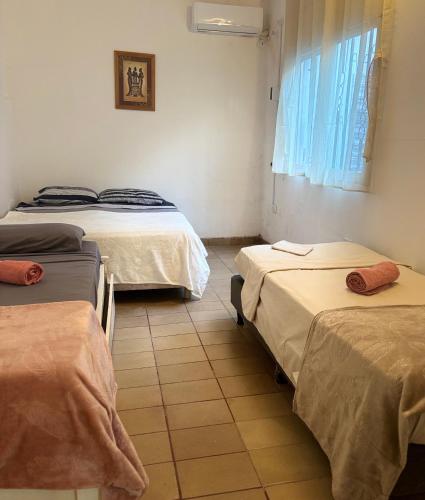 a room with three beds and a window at El Descanso in Posadas