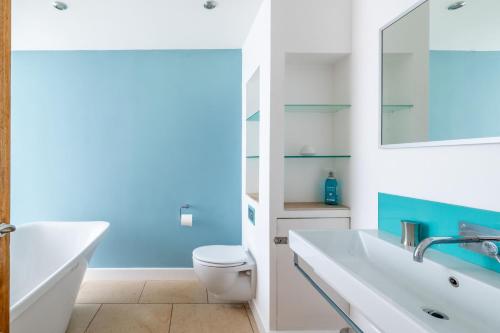 a bathroom with a white sink and a toilet at Sedum House in Gimingham