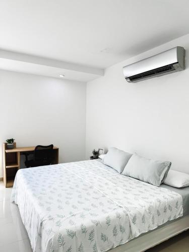 ein Schlafzimmer mit einem weißen Bett mit einem Licht an der Decke in der Unterkunft Modern Studio Apartment in downtown Yopal in Yopal