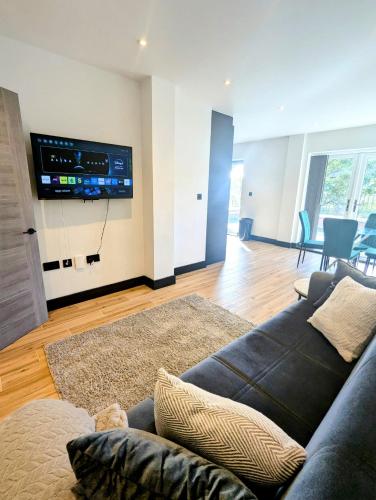 a living room with a couch and a flat screen tv at Elegant 2 bed flat with balcony in London in Finchley
