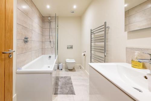 a bathroom with a tub and a sink and a toilet at Neathercoat in Wells next the Sea