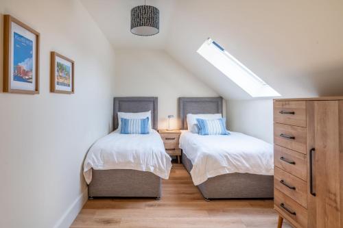 a bedroom with two beds and a dresser at Neathercoat in Wells next the Sea