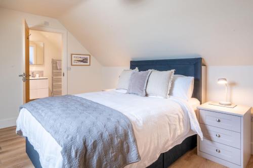 a bedroom with a large bed with a blue headboard at Neathercoat in Wells next the Sea