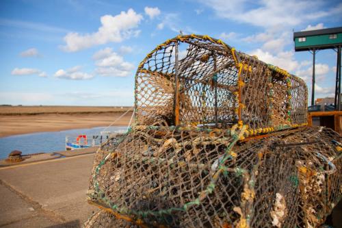a cage filled with nets on top of a beach at Neathercoat in Wells next the Sea