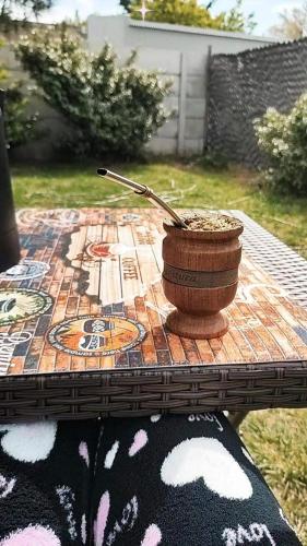 a wooden table with a pot and a spoon on it at Cabañas bahia in Bahía Blanca