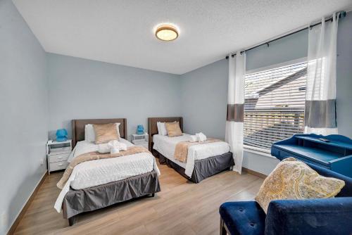 CanaOutdoor Relaxation! Port St Lucie Family Home的一间卧室配有两张床和蓝色的沙发