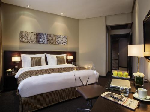 a hotel room with a large bed and a desk at Mövenpick Hotel Casablanca in Casablanca