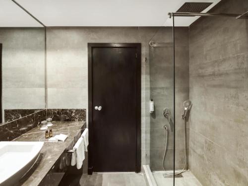 a bathroom with a shower and a black door at Mövenpick Hotel Casablanca in Casablanca