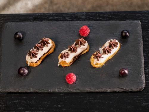 three donuts with chocolate and raspberries on a black plate at Mövenpick Hotel Casablanca in Casablanca