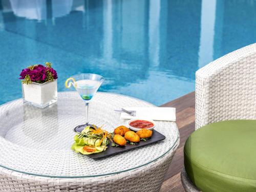 a plate of food on a table next to a pool at Mövenpick Hotel Casablanca in Casablanca