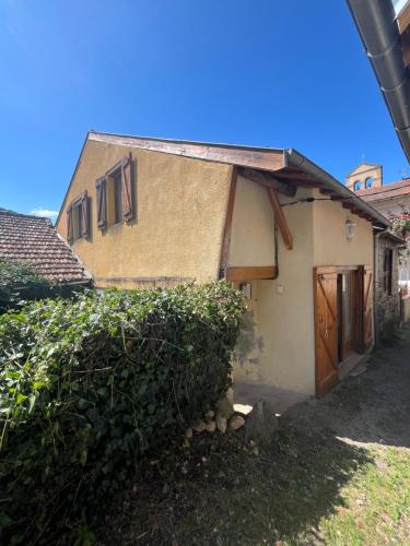 a small house with a wooden door in a yard at Gîte montagnard plateau de Beille in Les Cabannes