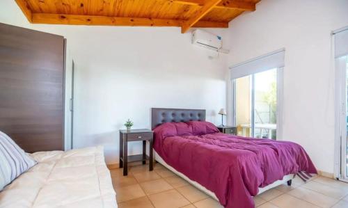 a bedroom with a large bed with a purple blanket at Cabañas bahia in Bahía Blanca