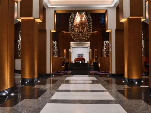 a hallway of a hotel with a chandelier at Mövenpick Hotel Mansour Eddahbi Marrakech in Marrakech
