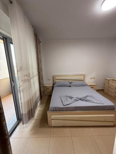 a bedroom with a bed and a large window at Flat in Shkoder in Shkodër