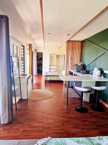 a living room with a table and a kitchen at Fare Toahana, logement chez l'habitant in Faaa